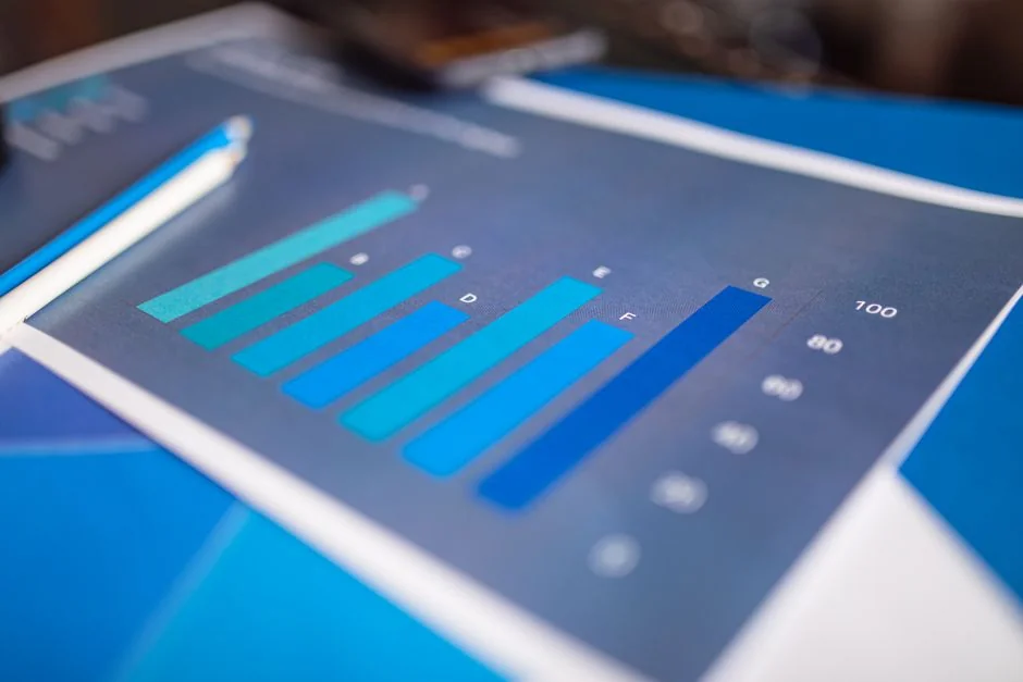 Une main tient un smartphone affichant un graphique BTC-USD au milieu d’écrans de trading numériques, mettant en avant la finance crypto.